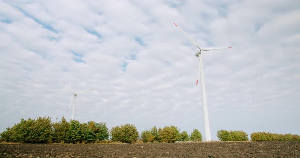 The Wind Turbines of the Windmills Work in an Arable Field Power Station