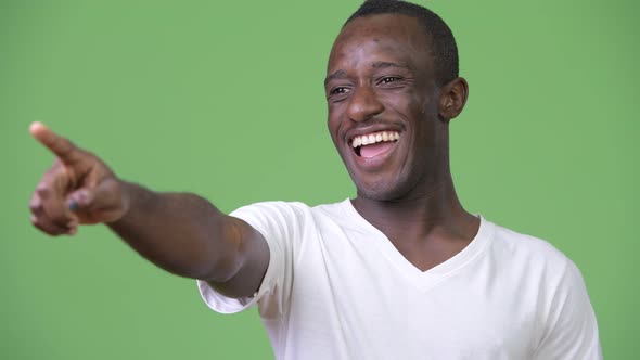 Young Happy African Man Smiling While Pointing Finger at Distance