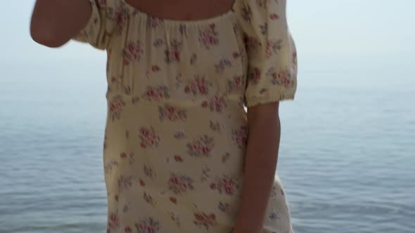 Laughing Woman Spinning Bouncing on Sea Water Holding Straw Hat Close Up