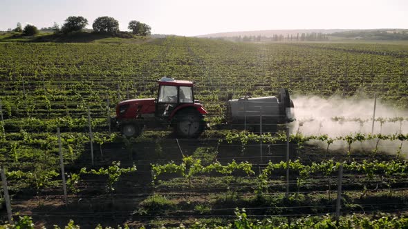 Tractor Spraying of Pesticides and Insecticides on an Agricultural Field. Agriculture concept.