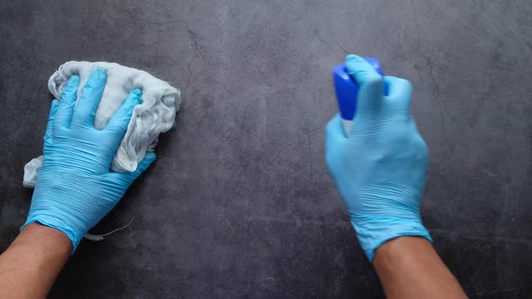 Man Hand in Protective Gloves Disinfecting Flat Surface 