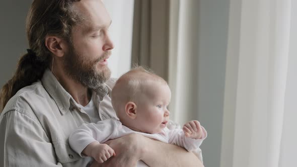 Closeup Caucasian Father Bearded Daddy Holding Baby Daughter Son Infant Newborn Looking Out Window