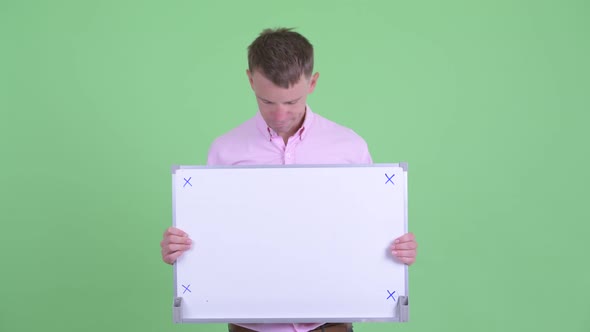 Stressed Businessman Holding White Board and Getting Bad News