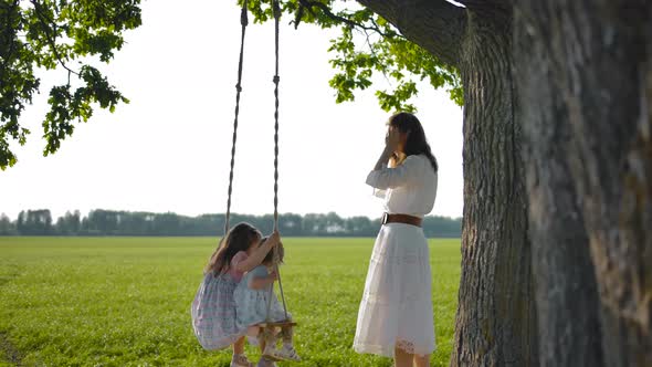 Mom Shakes Her Babes, 1 and 3 Years Old, on a Swing Tied To an Oak Tree.