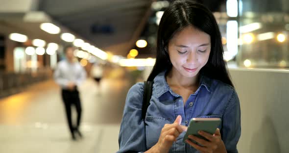 Woman using smart phone in city 