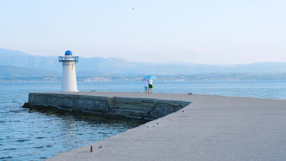 Two Boys Playing on the Pier Near Lighthouse. Young Tourists Having Fun on Quayside