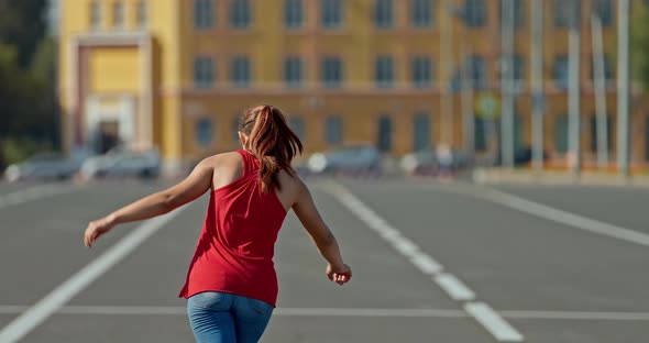 Beautiful Girl is Spinning on Roller Skates Balancing Her Arms