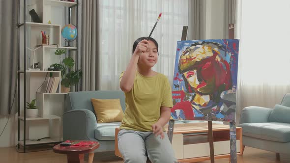 Asian Artist Girl Holding Paintbrush Wipe The Sweat Before Crossing His Arms And Smiling