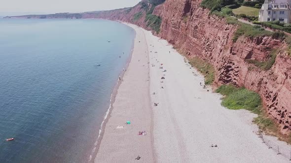 Soaring up over the red sandstone cliffs of the Jurassic Coast, UK, AERIAL STATIC CROP