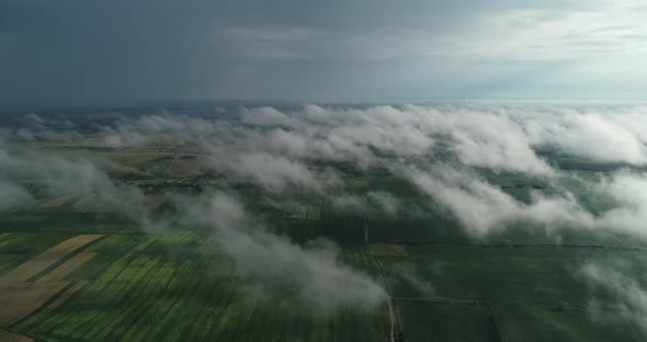 Green Fields Of Aerial View Can Be Seen Through The Clouds. 