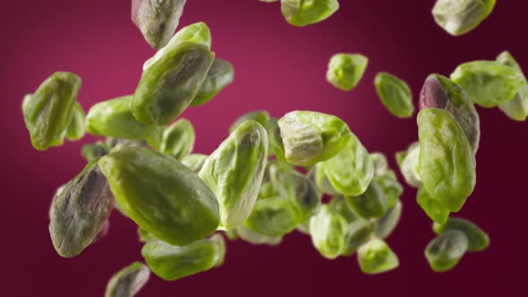 Flying of Peeled Pistachios in Deep Fuchsia Background