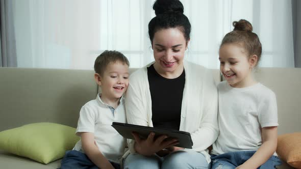 Happy Mom and Cute Daughter Little Kidmother Playing with Child at Home Relaxing Use a Smartphone