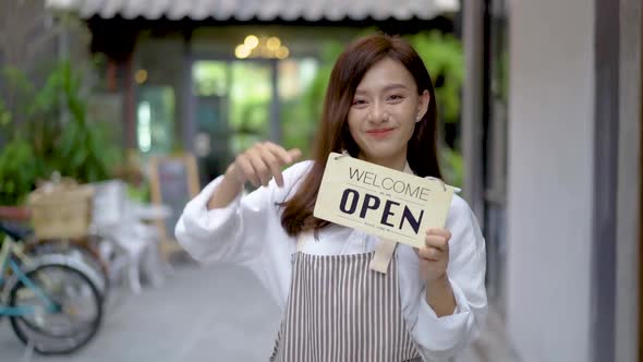 Business owner happy beautiful young asian woman looking at camera, welcoming clients to new cafe