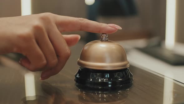 Hand Ringing Service Bell on Hotel Reception Desk