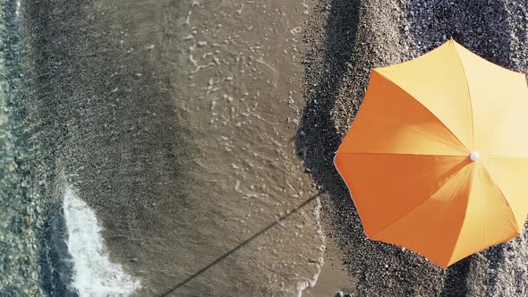 Beach Umbrella at Sunset Light Near the Ocean Waves