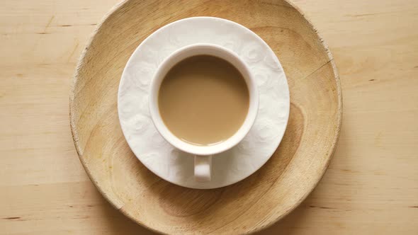 Top View of Cup with Aromatic Coffee with Milk on on Wooden Table