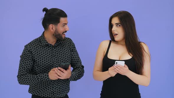 Handsome Cuban Bearded Man in His 30s and His Sexy Longhaired Girlfriend Holding Their Smartphones