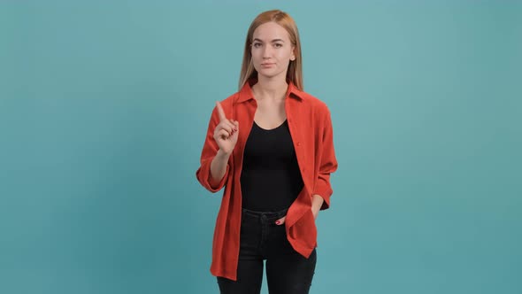 Upset Woman That Showing No with Her Finger Posing on Turquoise Background