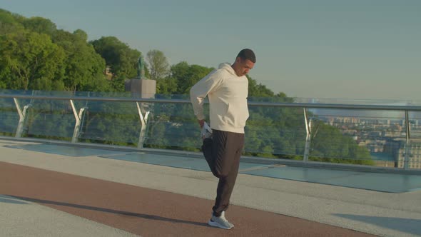 Determined Sporty Fitness Black Man Stretching Legs Before Run Outdoor at Dawn