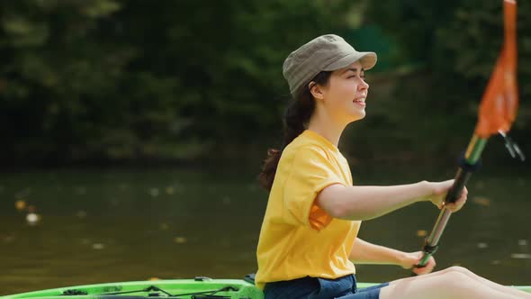 Caucasian woman learning to rowing in a kayak.View from water surface.