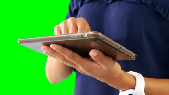 Woman using digital tablet against green screen