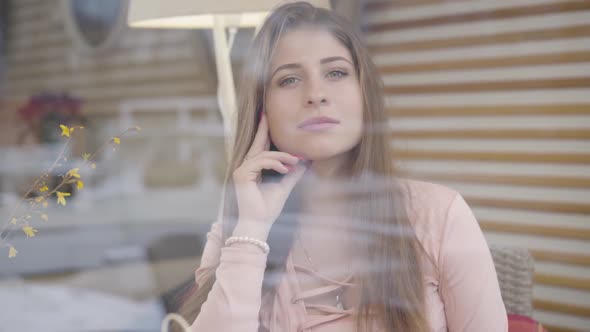 Portrait of Gorgeous Brunette Grey-eyed Caucasian Girl Behind Window Glass, Confident Young Woman