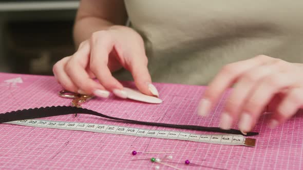 Woman Dressmaker Making Chalk Marks on Ribbon Using Centimeter Tape Closeup and Cutting with