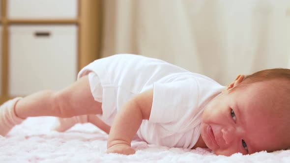 Crying Baby Girl Lying on Knitted Plush Blanket