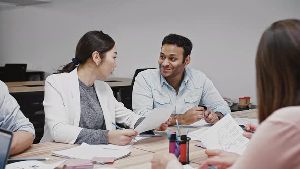 Multiethnic Diverse Colleagues Discussing Details Concerning Startup Project During Brainstorming