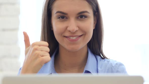 Thumbs Up by Woman Sitting in Office for Work