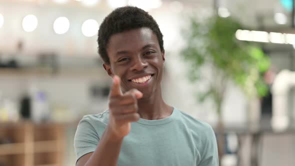Young African Man Pointing at the Camera