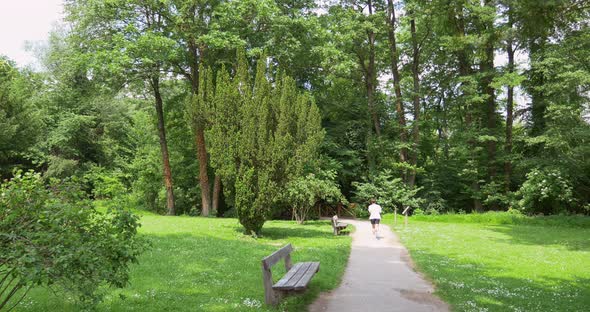 Young man running at path in green park