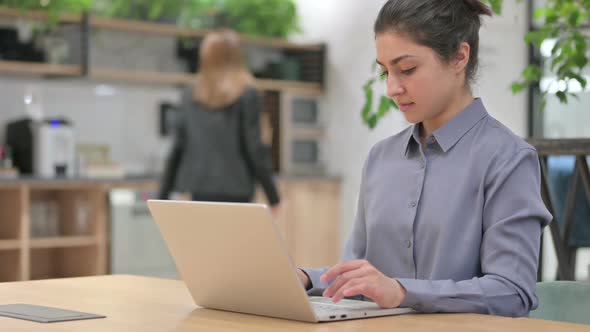 Young Indian Woman Working on Laptop in Office