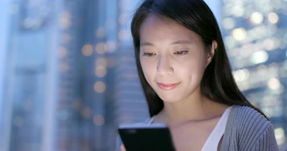 Young Business woman look at smart phone in city at night