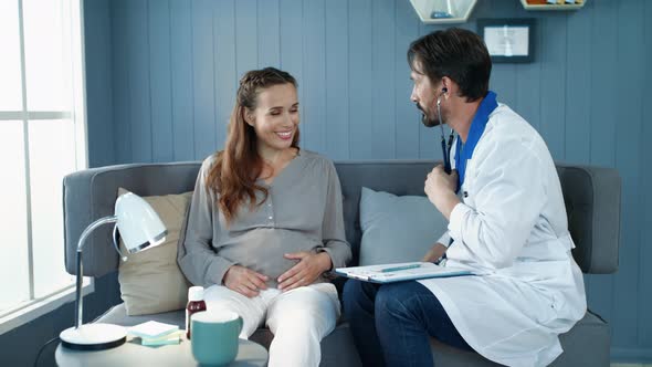 Closeup Doctor Checking Pregnant Woman Belly with Stethoscope in Office.