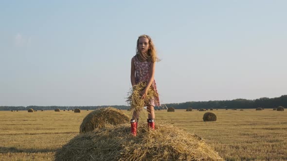 Cute Little Girl Having Fun on a Hay Bale