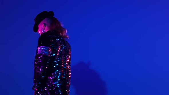 Young Stylish Man Dancing in Style Michael Jackson, Spotlight on a Blue Background. Close Up, Slow