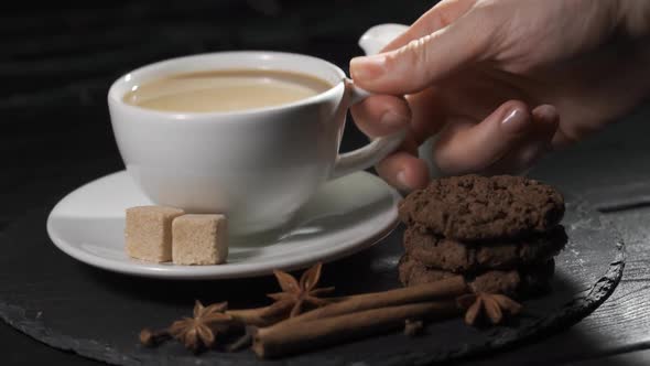 Female Hands Takes a Cup of Coffee. Woman Warms Her Hands with Hot Coffee Cup