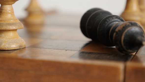 Wooden chess set match ends shallow DOF  4K 2160p 30fps UltraHD  footage - Knocking down black playe alt