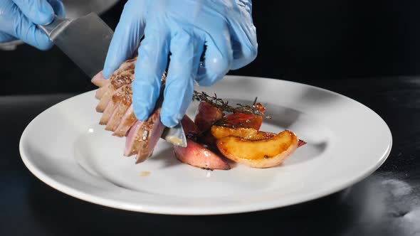 Serving Restaurant Meat Dish on Plate, Close Up, Chef Putting Sliced Roasted Meat on Plate