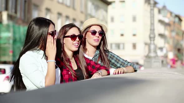 Three happy women walking in the city