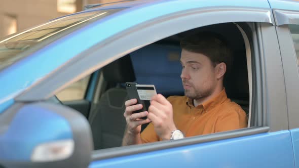 Young Man Reacting to Online Payment Failure while Sitting in Car