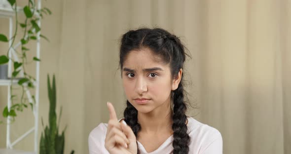 Portrait of Young Indian Caucasian Teen Girl with Serious Expression Looking at Camera Waving Her