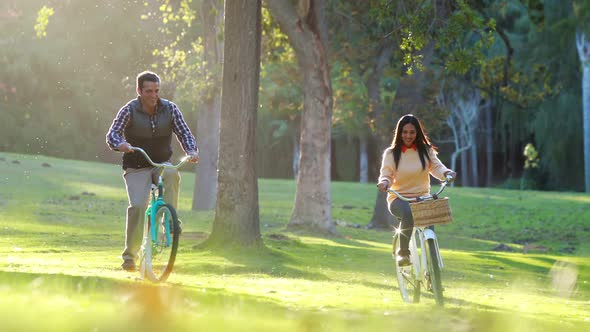 Happy couple cycling in park