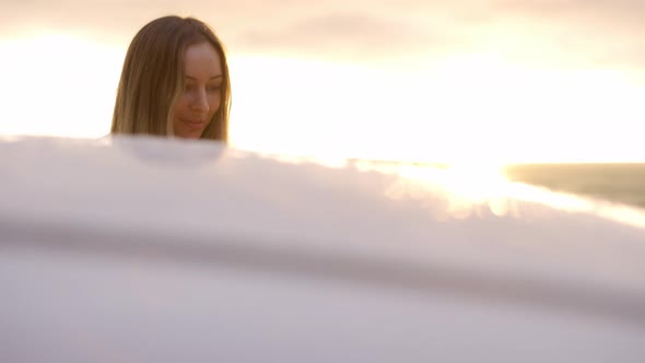 Blonde Woman Getting Into Car on the Coast During Golden Hour