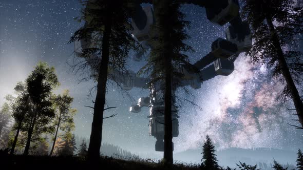 UFO Hovering Over a Forest at Night with Light Beam alt