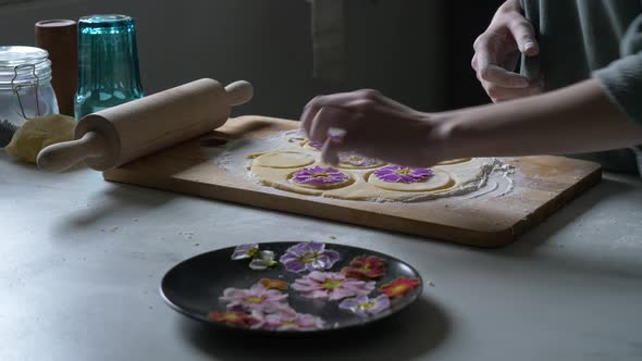 Woman making cookies with Primula petals