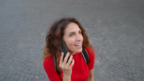 Curly Woman Talking on Phone Outdoors