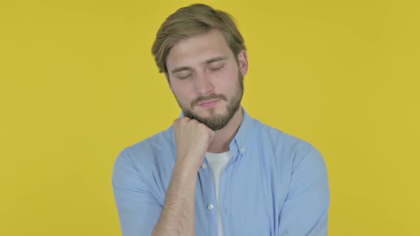 Young Man Sleeping on Yellow Background