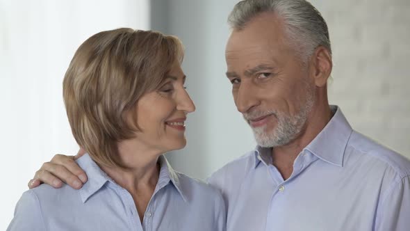 Happy Elderly Couple Looking at Each Other and Smiling at Camera, Advertising